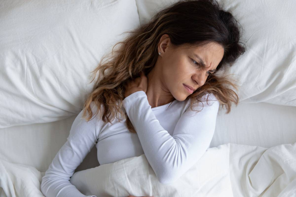 Woman whose sleep position causes back problems and neck pain