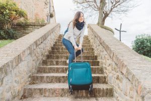 Picture of woman drags her heavy luggage upstairs
