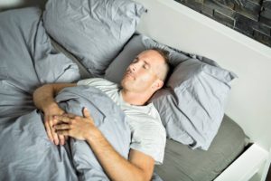 Man sleeping on back after spine surgery